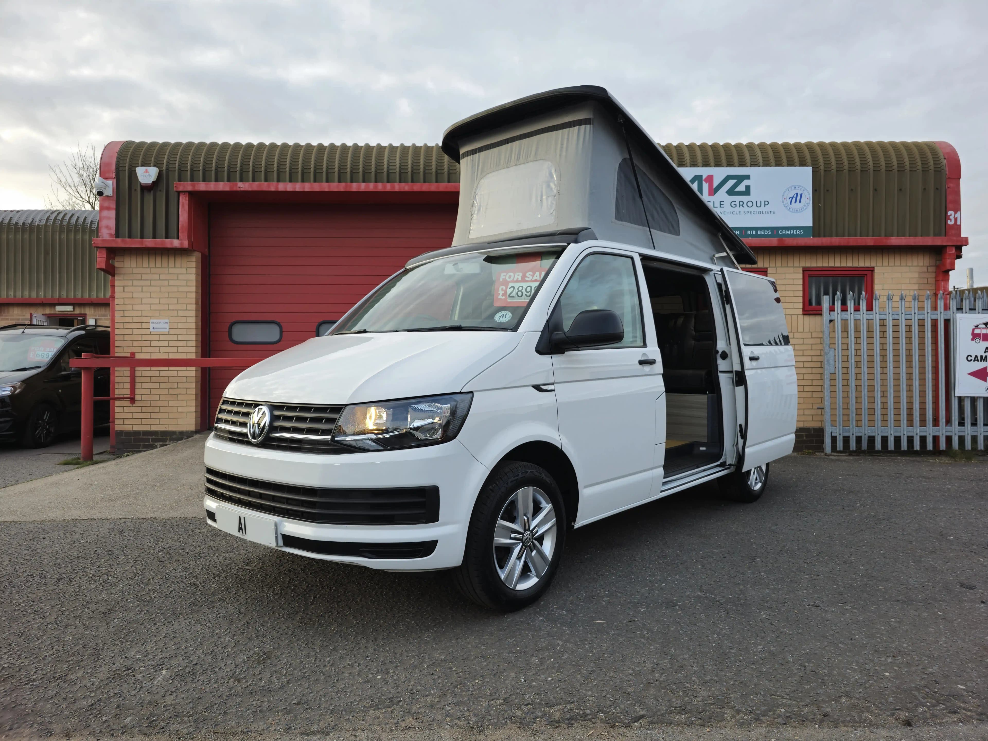 A white volkswagen van that has been converted to campervan.