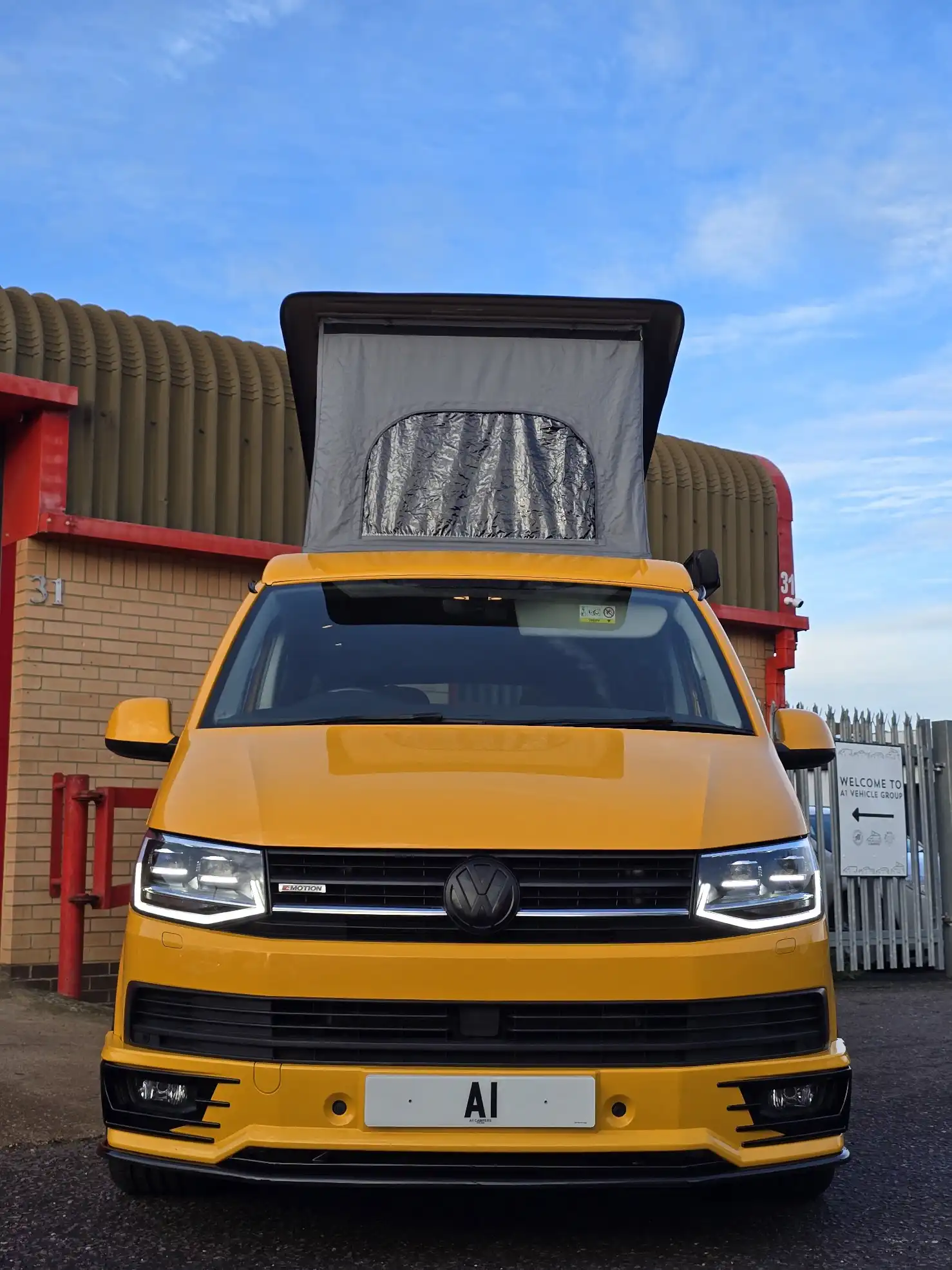 A white volkswagen van that has been converted to campervan.