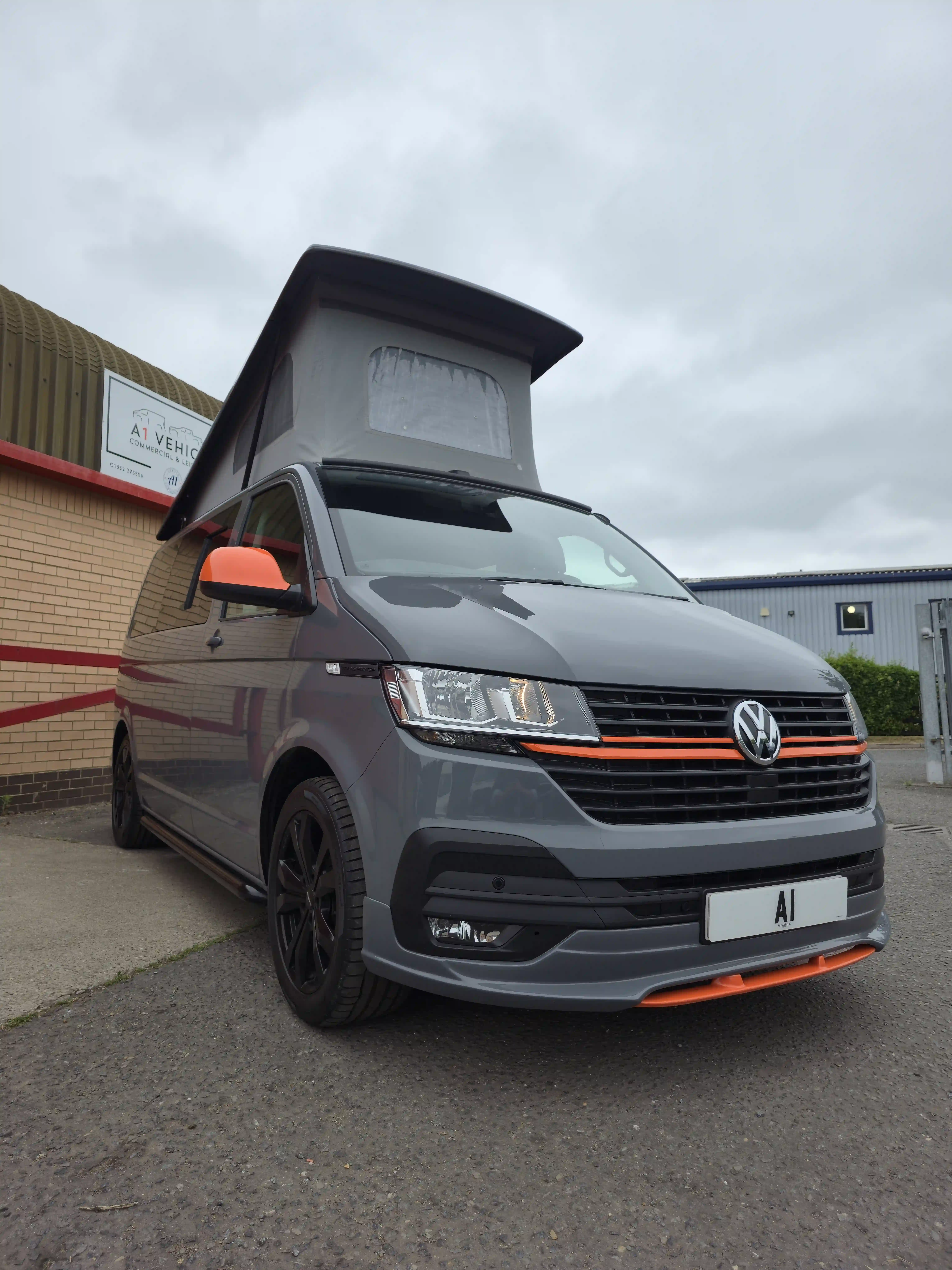 A white volkswagen van that has been converted to campervan.